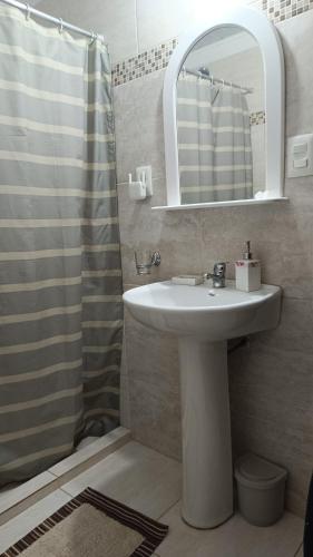 a bathroom with a sink and a shower with a mirror at Rincón del Hum in Mercedes
