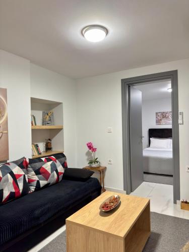 a living room with a black couch and a table at The Central Retreat 1 in Mytilene