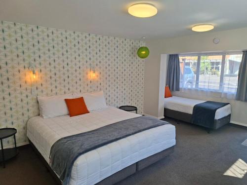 a bedroom with two beds and a window at RotoVegas Motel of Rotorua in Rotorua
