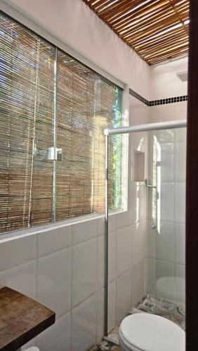 a bathroom with a glass shower and a toilet at Casa Jasmim in Marau