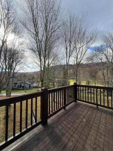 a wooden deck with a fence and trees at Effortless access to ski slopes•Endless relaxation in Beech Mountain