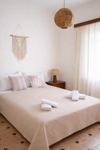 a bedroom with a large bed with towels on it at Sounio Garden Retreat in Panayía