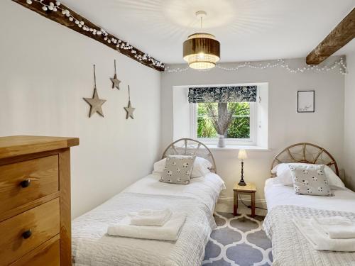 a bedroom with two beds and a window at The Old Malt House Exton in Exton