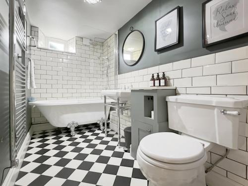 a bathroom with a toilet and a tub and a sink at The Old Malt House Exton in Exton