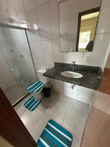 a bathroom with a sink and a toilet and a mirror at Apt Pituba 500m Praia in Itacaré