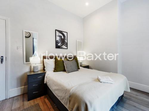a bedroom with a large bed and a dresser at Hackney Guest Rooms in London
