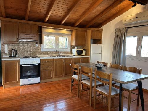 a kitchen with a wooden table and chairs and a kitchen with a stove at Stavroula's House in Argyrádes