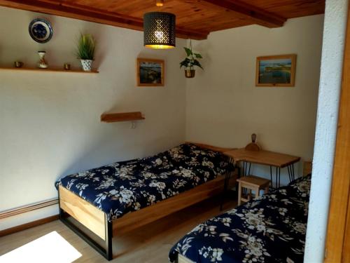 a room with two beds and a table in it at Wigierska Chatka in Gawrych Ruda