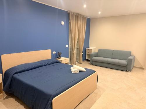 a blue bedroom with a bed and a couch at Sofia s Rooms in Falcone