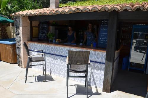 two chairs sitting in front of a bar at La Bergerie Du Cap in Cap d'Agde