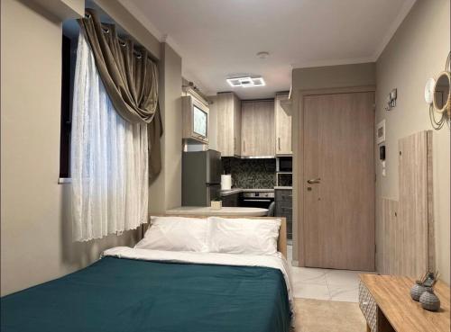 a bedroom with a large bed and a kitchen at Bloom Garden 1 in Mytilene