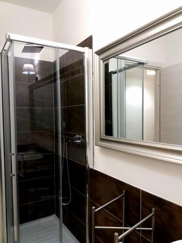 a bathroom with a glass shower with a mirror at Flat via Irlanda 26 in Quartu Sant'Elena