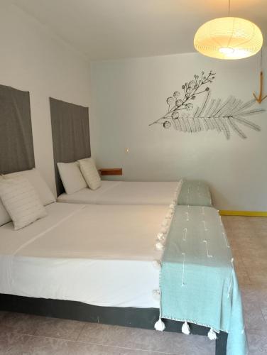 a room with two beds and a table in it at Un Sueño Valle de Huajes in Oaxaca City