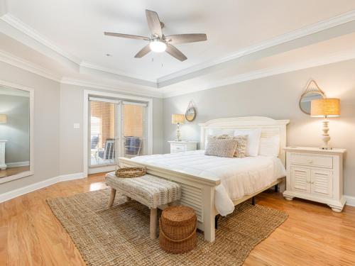 a bedroom with a white bed and a ceiling fan at Brass Rail 310 in Tybee Island