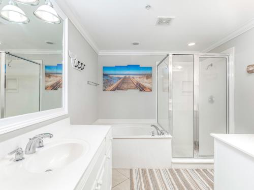 a white bathroom with a shower and a sink at Brass Rail 310 in Tybee Island