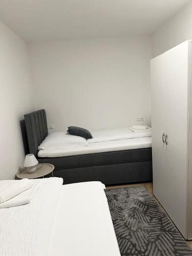 a bedroom with two beds and a chair and a mattress at Ferienwohnung am Wildpark Eichert HDH in Heidenheim an der Brenz