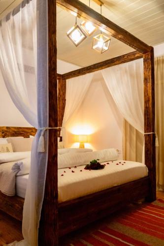a bedroom with two beds with white drapes at Sadova Village - Casa Maria in Sadova
