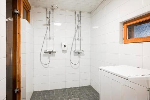 a bathroom with a shower with white tiles at Mökki Vierumäki in Myllykylä