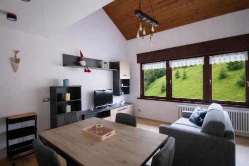 a living room with a wooden table and a couch at IL CERVO - 2 camere, garage Dolomiti Affitti in Cavalese