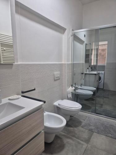a bathroom with two toilets and a sink and a shower at Dimora del Funaro con parcheggio in Orvieto