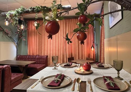 a table with plates and utensils in a restaurant at Арт Спектър Камп in Bratsigovo