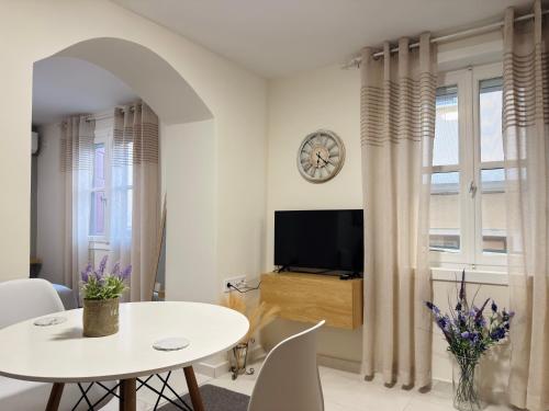 a living room with a white table and a tv at The Central Retreat 2 in Mytilene