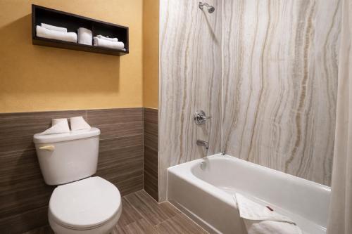 a bathroom with a toilet and a shower and a tub at Super 8 by Wyndham Pasadena in Pasadena