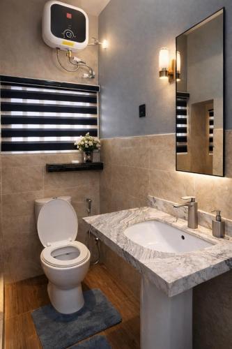 a bathroom with a toilet and a sink at Luxury 6 bedroom villa in independence layout 247 power parking and Wifi in Enugu