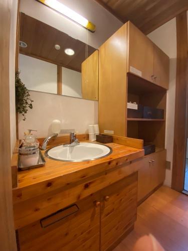 a bathroom with a wooden counter with a sink at Guest House Eleven Village Fukiya in Fukiya