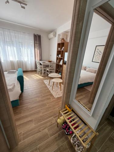 a living room with a mirror and a bedroom at Ljiljana in Vršac