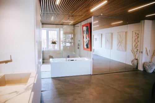 a large bathroom with a tub in a room at The living gallery in Roja