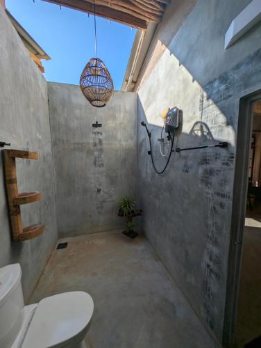 a bathroom with a toilet and a potted plant at Hotelito Sri Lanka in Weligama