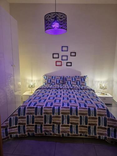 a bedroom with a large bed with a purple comforter at Al Piccolo Cassaro in Caltanissetta