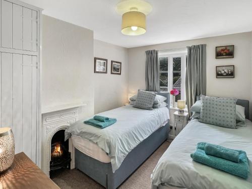 a bedroom with two beds and a fireplace at Grace Cottage Porlock in Porlock