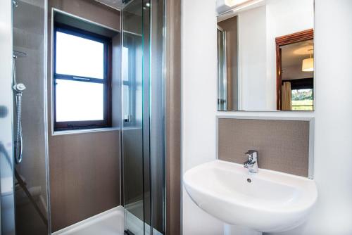 a bathroom with a sink and a shower at The Smithy nr Huntsham in Tiverton