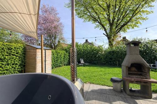 a patio with an outdoor oven in a yard at Pure Wellness Bungalows 52 Sauna&Hottub in Ewijk