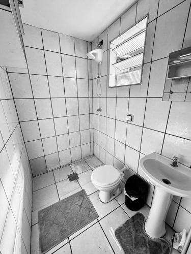 a bathroom with a toilet and a sink at Casa de fundo aconchegante 4 solteiros ou 5 se 2 pessoas na casal in Campinas