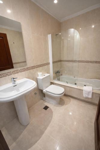 a bathroom with a sink and a toilet and a tub at PENSION LUCERNA in Vigo
