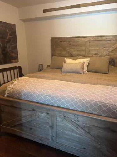 a bed with a wooden headboard in a bedroom at La Félicita chalet in Saint Adolphe D'Howard