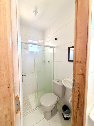 a bathroom with a toilet and a glass shower at Torres Residence 2 in Recife