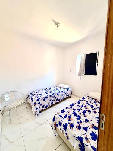 a bedroom with two beds and a chair in it at Torres Residence 2 in Recife