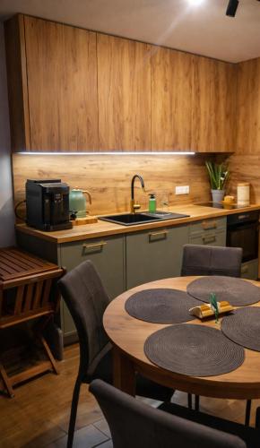 a kitchen with a table and chairs and a sink at Apartament Słoneczna Dolina SPA Belle View in Szklarska Poręba