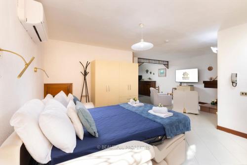 a bedroom with a blue bed with white pillows at Room with kitchen & free parking 100 m from the sea in Quartu Sant'Elena