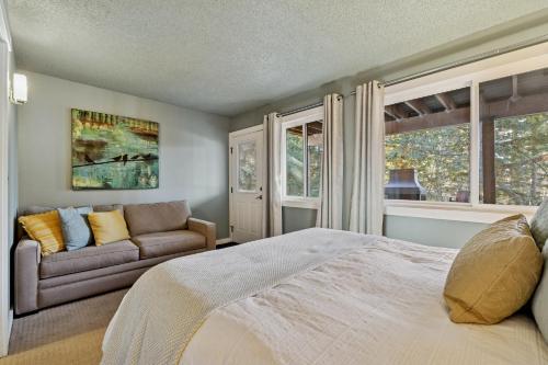 a bedroom with a bed and a couch and windows at Moose Tracks in Whitefish