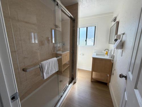 a bathroom with a glass shower and a sink at Carmel Resort Inn in Carmel