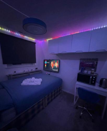 a room with a bed and a flat screen tv at Room 3 minute drive from Luton Airport in Luton