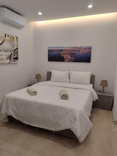 a bedroom with a large white bed with two pillows at Blue bay Sliema in Sliema
