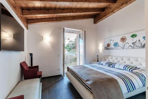 a bedroom with a bed and a chair and a window at Terrazzo apartment in Bellagio