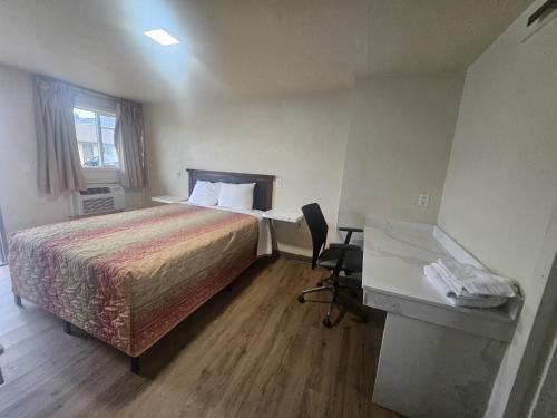 a hotel room with a bed and a desk at Del Rancho Motel in Portland