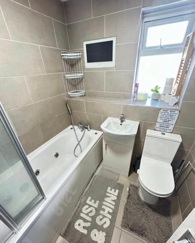 a bathroom with a toilet and a tub and a sink at Room 3 minute drive from Luton Airport in Luton